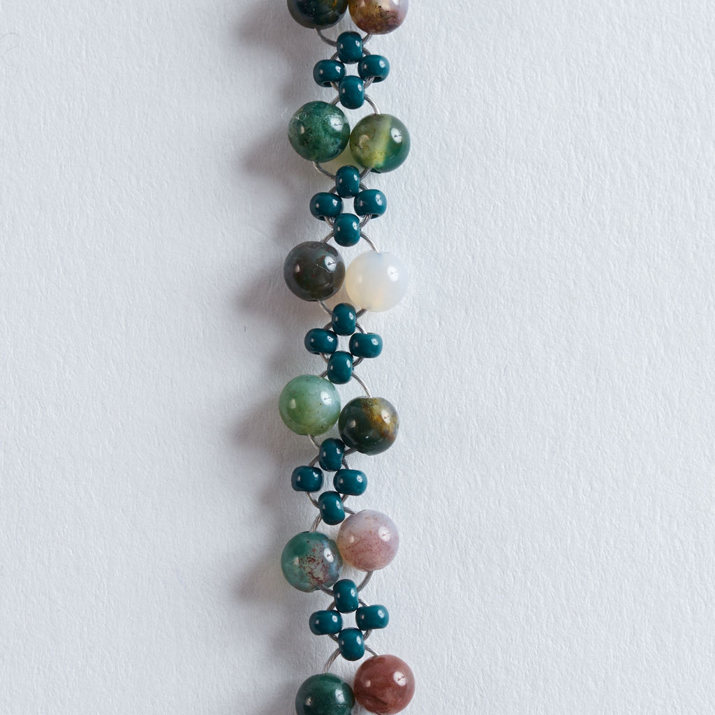 Farbe
Verschiedene Grüntöne, Naturbeige, Cremeweiß, feine marmorierte Steinstrukturen, goldene Akzente.