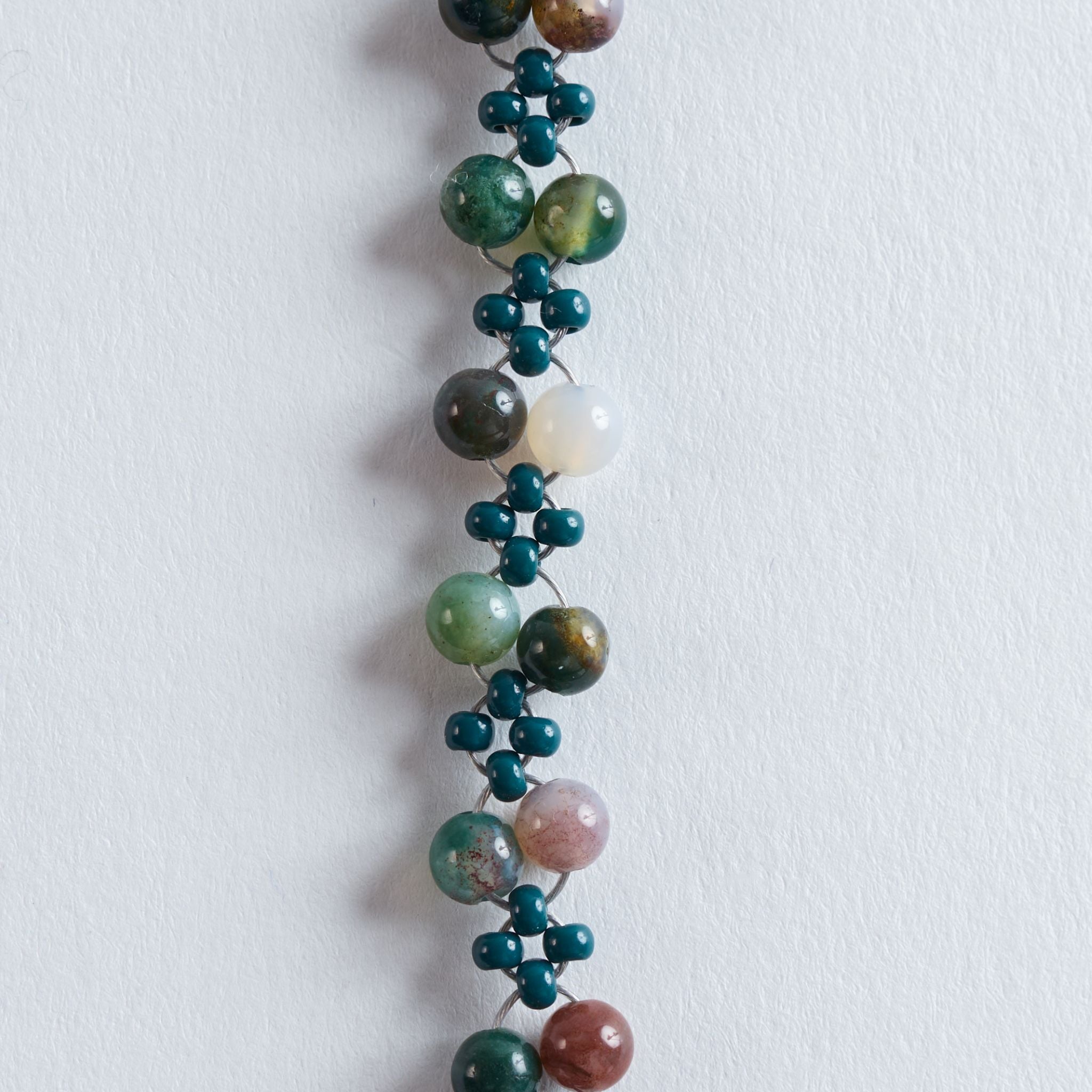 Farbe
Verschiedene Grüntöne, Naturbeige, Cremeweiß, feine marmorierte Steinstrukturen, goldene Akzente.