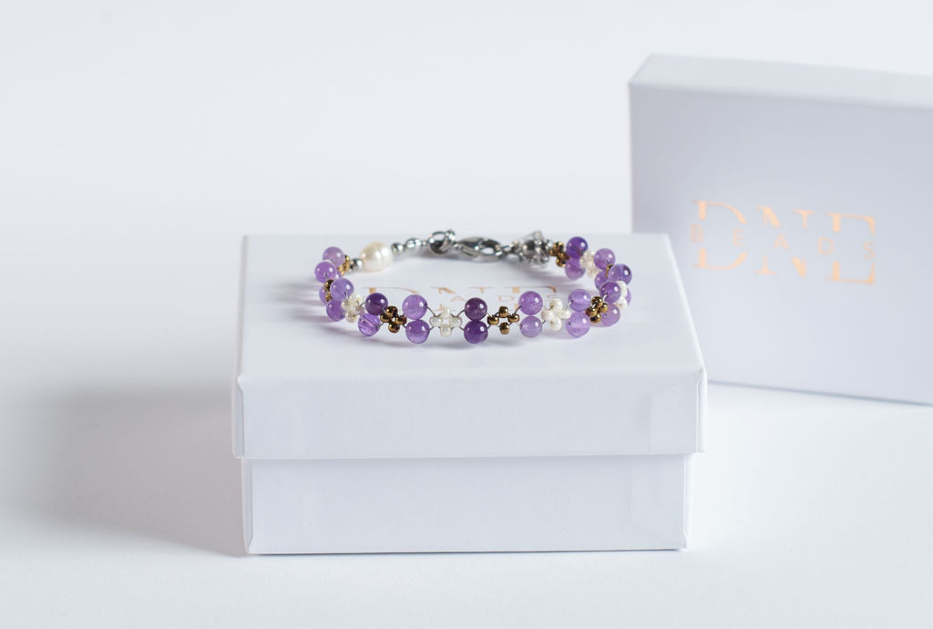 Das Violet Flow Twister – Armband verbindet sanfte Amethyststeine mit kleinen, cremig-weißen Glasperlen und feinen goldfarbenen Akzenten.

Durch die Twister-Struktur entsteht ein weiches, lebendiges Muster, das dem Armband eine natürliche Bewegung verleiht.

Die zarten Violetttöne wirken klar und leicht, während die hellen Elemente dem Design Ruhe und Wärme schenken.