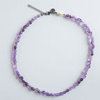 Geschliffene Amethyststeine in sanftem Violett bilden das Zentrum der Halskette "Violet Flow". Die natürliche Transparenz und die ungleichmäßige Struktur des Steins sorgen für einen authentischen, ruhigen Look.
