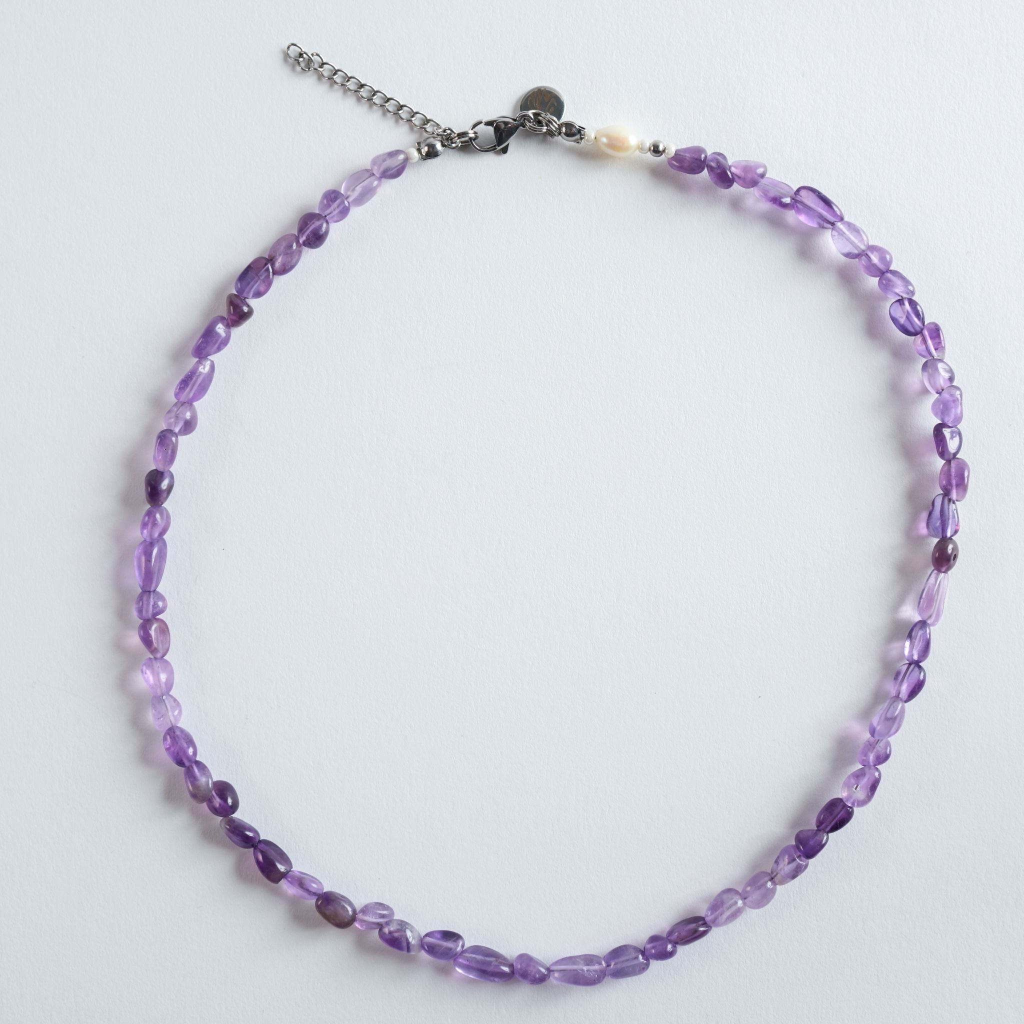 Geschliffene Amethyststeine in sanftem Violett bilden das Zentrum der Halskette "Violet Flow". Die natürliche Transparenz und die ungleichmäßige Struktur des Steins sorgen für einen authentischen, ruhigen Look.
