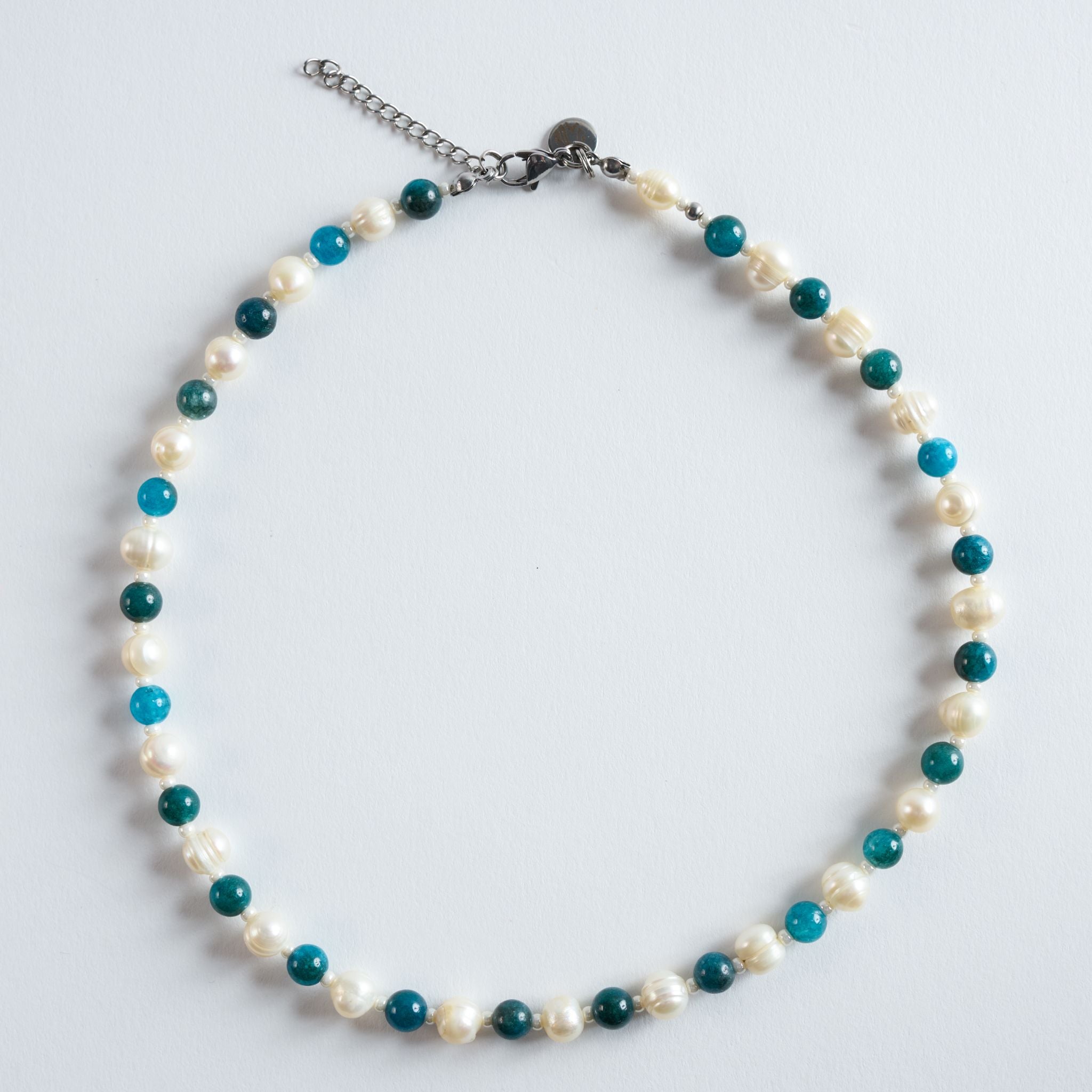 Ocean Pearl kombiniert echte Apatitsteine mit schimmernden Süßwasserperlen. Die klare Türkisfarbe erinnert an das Meer und verleiht der Kette einen lebendigen, sommerlichen Charakter. Jeder Apatit besitzt seine eigene Struktur und wirkt im Zusammenspiel mit den Perlen natürlich und edel.