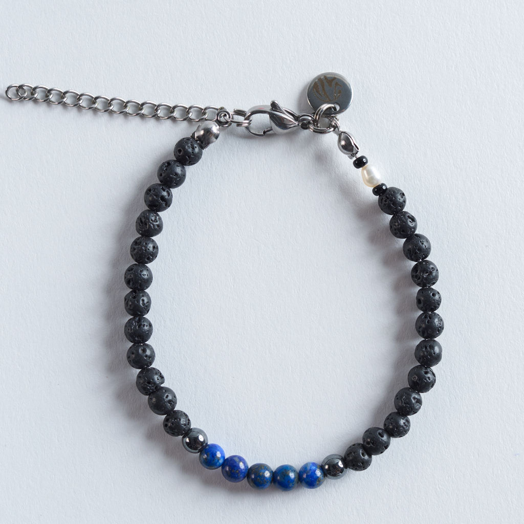 Das Armband Blue Lava verbindet die matte, natürliche Tiefe von Lavastein mit der kühlen Eleganz von Hämatit und der intensiven Farbwirkung echten Lapislazulis.

Die Kombination aus Schwarz, Silber und leuchtendem Blau erinnert an dunkle Felsformationen, die auf das tiefe Blau des Meeres treffen. Das Design wirkt kraftvoll, modern und klar. Ein stilvoller Akzent für jeden Tag.