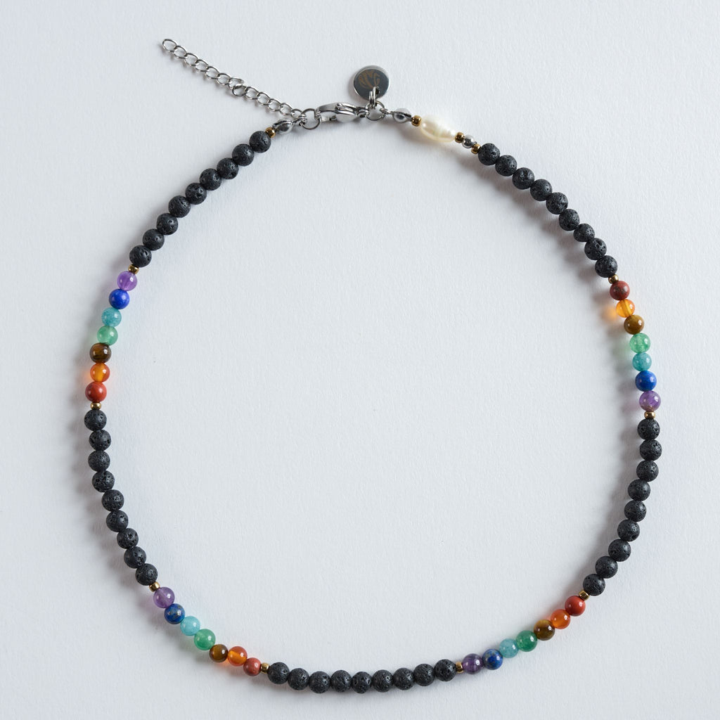 Die Kette „Colorflow Lava“ verbindet schwarzen Lavastein mit farbigen Halbedelsteinen, die in einem klaren Farbverlauf arrangiert sind. Die kräftigen Töne von Rot, Orange, Grün, Hellblau, Blau und Violett setzen moderne, dynamische Akzente und machen die Kette zu einem lebendigen Statement-Piece.