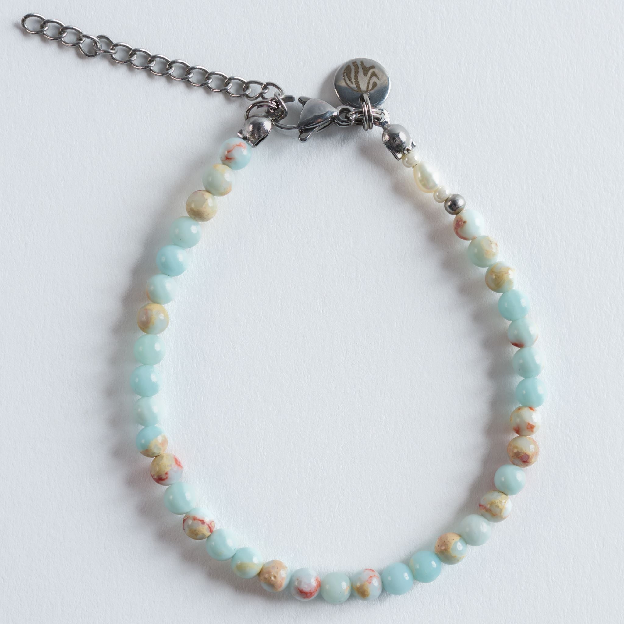Das Armband Cloud fängt die zarten Farben eines weichen Abendhimmels über dem Meer ein. Pastellige Blau, Mint, Beige und Apricotnuancen fließen sanft ineinander und erinnern an Wolken, die sich im warmen Licht über der Wasseroberfläche verfärben.