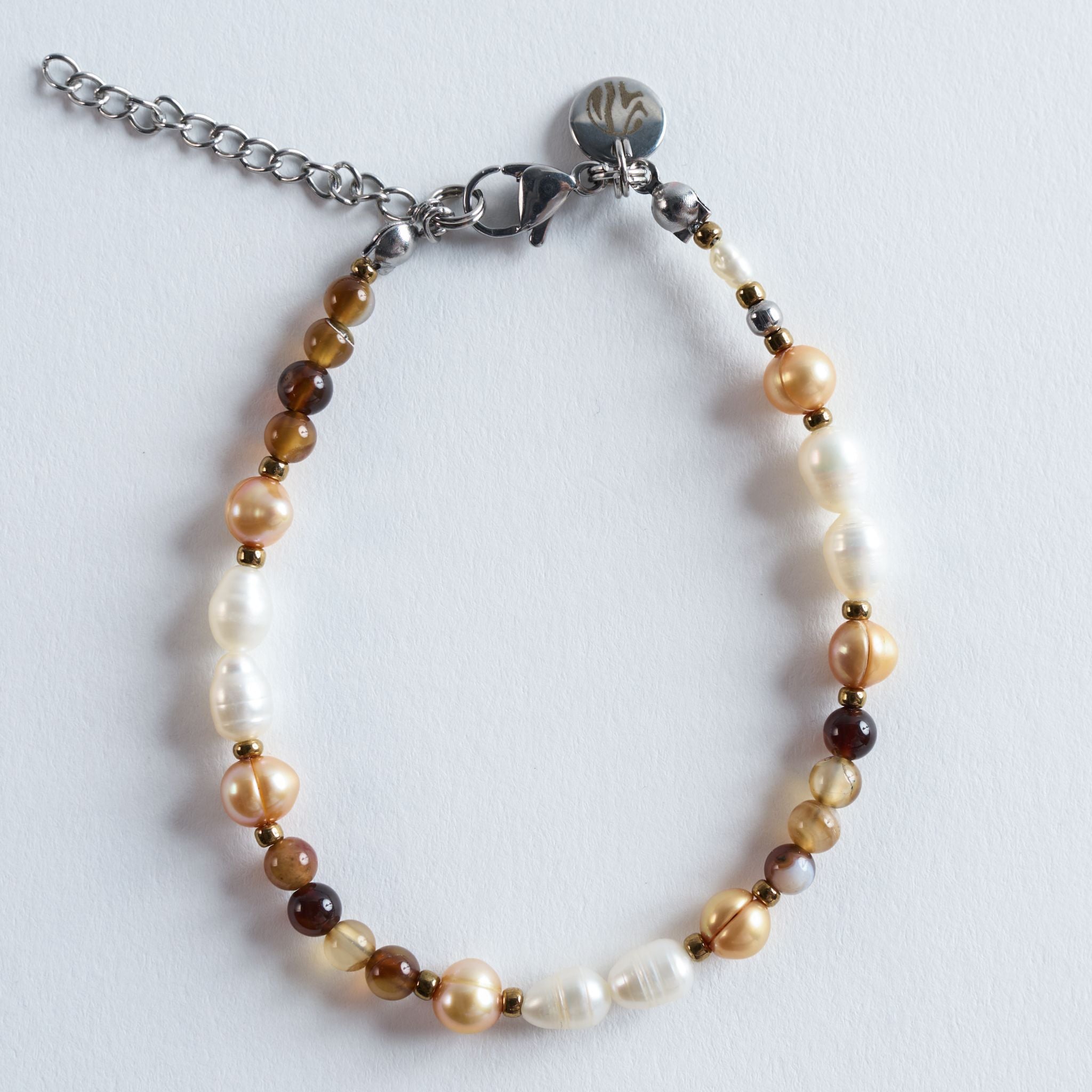 Das Armband Caramel Coast verbindet warme, sonnige Küstentöne mit der sanften Eleganz echter Süßwasserperlen. Die Mischung aus Caramelbraun, Creme und kleinen goldenen Akzenten erinnert an Strände im Abendlicht, an warmen Sand und ruhige Wellenbewegungen.