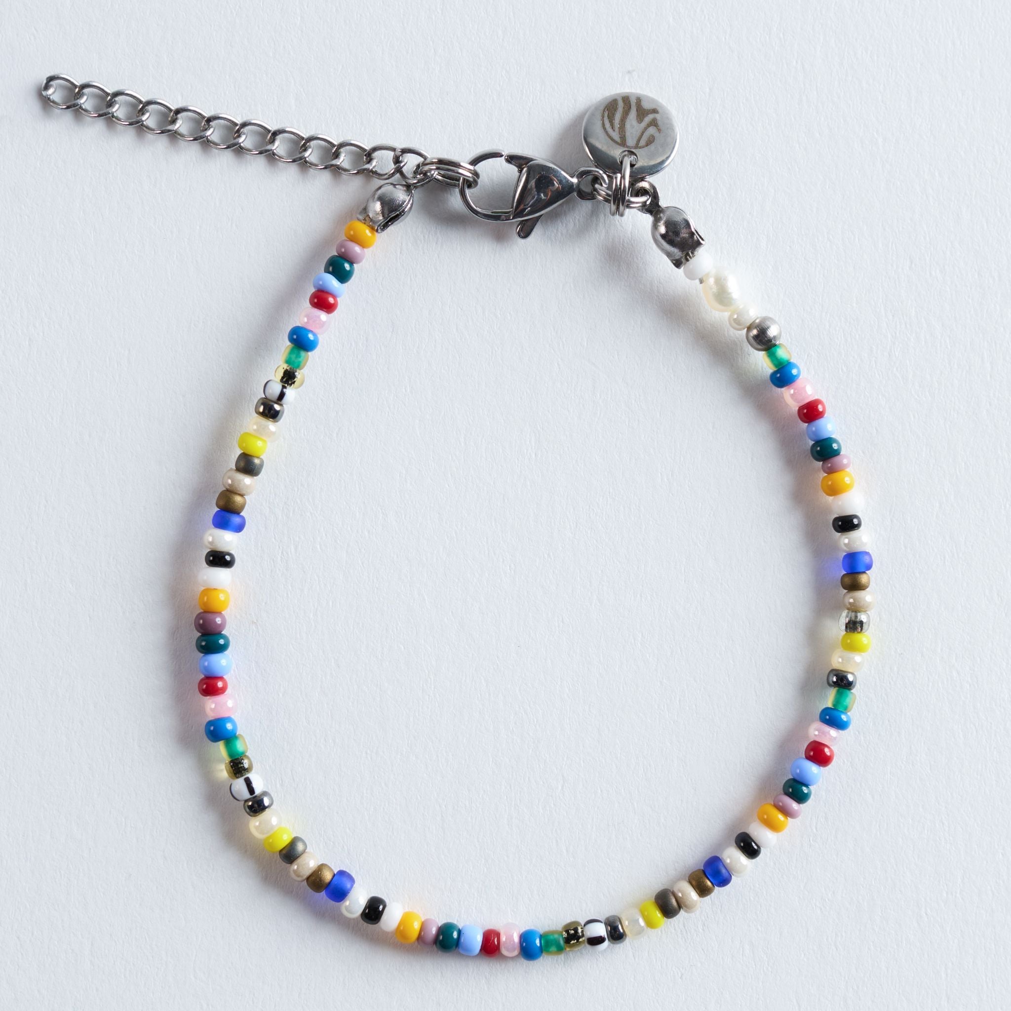 Das Armband Color Breeze bringt die leichte, farbenfrohe Ausstrahlung der gleichnamigen Halskette in einer feinen, schmalen Perlenreihe ans Handgelenk. Die sorgfältig zusammengestellten Glasperlen ergeben einen lebendigen, aber harmonischen Farbverlauf, der das Armband modern, frisch und vielseitig wirken lässt. Durch seine zarte Verarbeitung trägt es sich besonders angenehm und setzt einen dezenten, fröhlichen Farbakzent im Alltag.