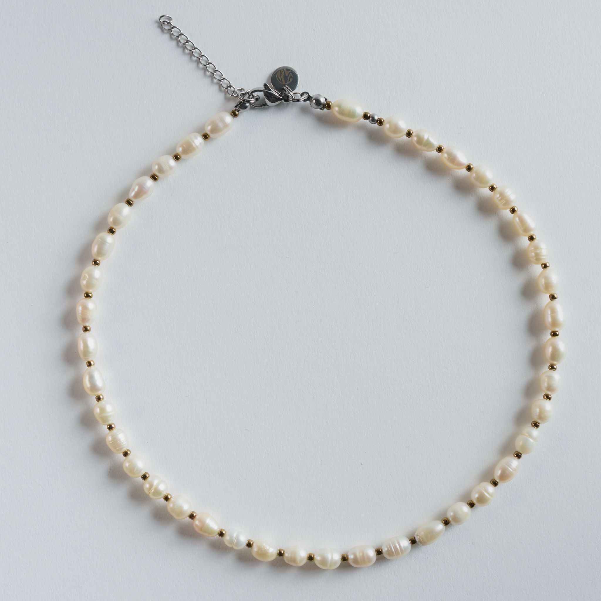 Diese Halskette "Pure Pearl" besteht aus fein abgestimmten, natürlichen Süßwasserperlen in klassischem Weiß.

Die leicht organischen Formen verleihen dem Design eine sanfte, elegante Ausstrahlung, während die klare Linienführung bewusst minimalistisch bleibt.