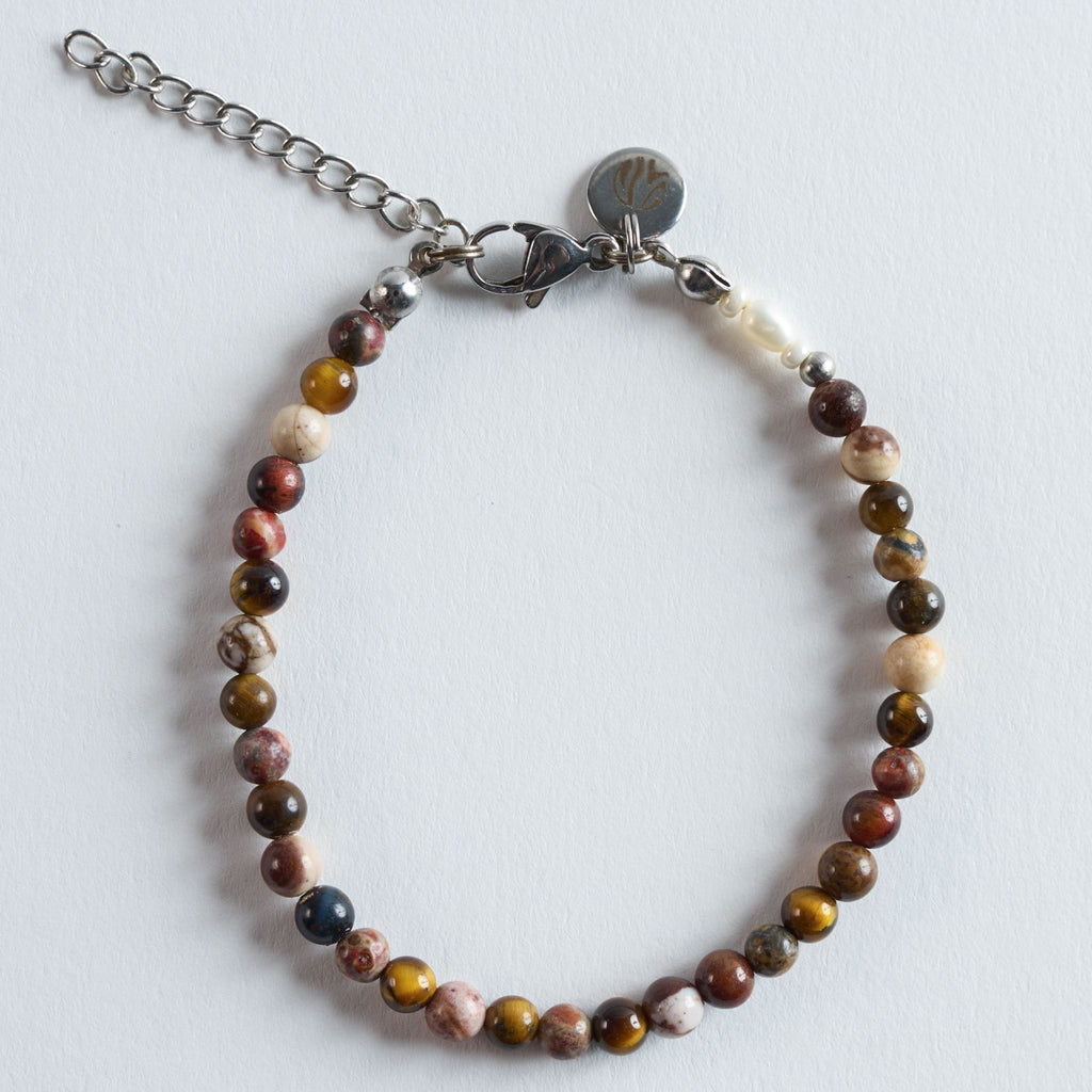 Das Armband Eye of the Tiger verbindet die warmen Goldbrauntöne von Tigerauge mit den natürlichen, erdigen Maserungen verschiedener Jaspis-Arten. Das Armband wirkt kraftvoll, erdig und ausgewogen. Die Kombination aus tiefen Brauntönen und helleren Steinstrukturen verleiht dem Design Tiefe und eine angenehm natürliche Wärme.