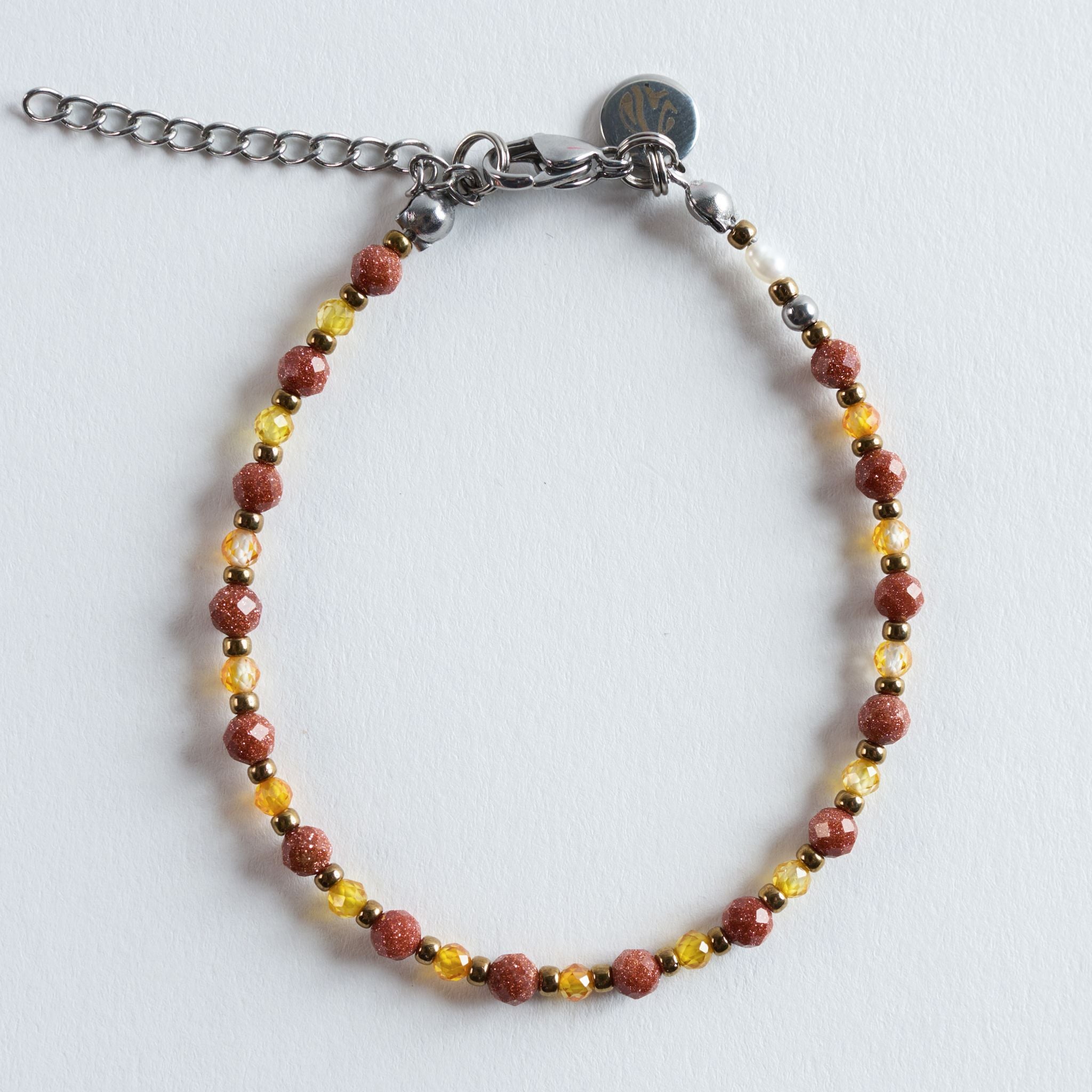 Das Armband Golden Sand fängt die warmen Nuancen eines ruhigen Sommerabends im Sand ein. Schimmernder Goldfluss trifft auf funkelnde Zirkonperlen und feine goldene Akzente. Gemeinsam entsteht ein lebendiges, zugleich harmonisches Farbspiel, das dem Armband eine sanfte, sonnige Ausstrahlung verleiht.