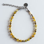Shine Yellow bringt warme Gelbtöne und goldene Reflexe ans Handgelenk. Die Kombination aus sanft leuchtendem Gelb und facettierten Goldakzenten erinnert an Sonnenstrahlen und verleiht jedem Outfit eine freundliche, strahlende Note.