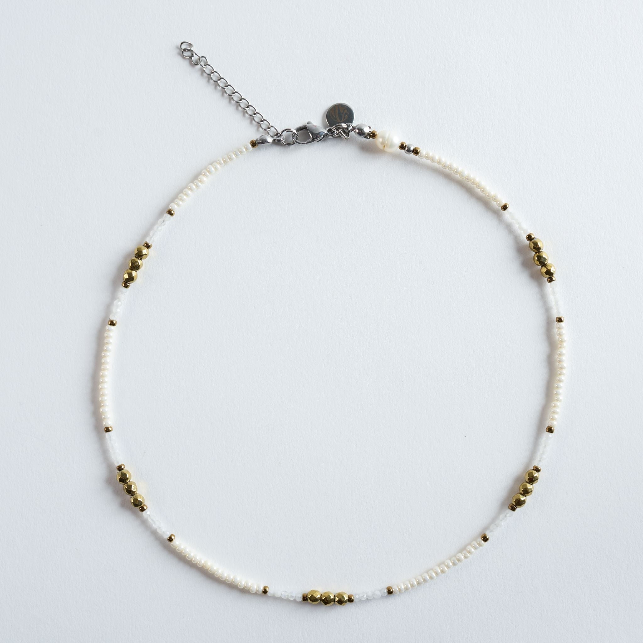 Die Halskette „Ivory“ kombiniert feine, helle Perlen mit goldenen Akzenten zu einem klaren, eleganten Design. Die zarten Weiß- und Cremetöne wirken leicht und modern, während die goldfarbenen Hämatitdetails dem Schmuckstück eine hochwertige, warme Note verleihen. Ein minimalistisches, stilvolles Modell, das sich vielseitig stylen lässt – ob einzeln oder im Layering.