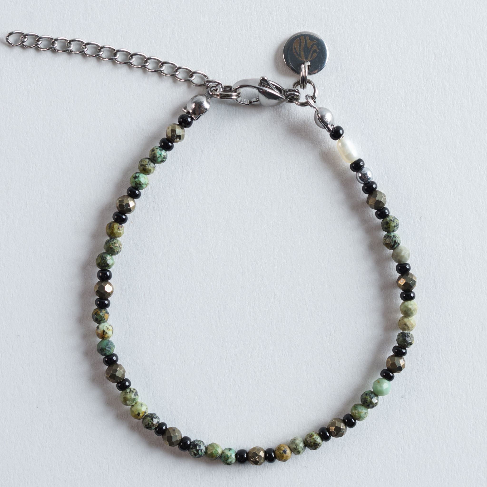 Das Armband Dark Forest fängt die Tiefe eines schattigen Waldes ein. Dunkle Glasperlen setzen klare Kontraste zu den grün marmorierten Steinen und lassen ein ausdrucksstarkes, zugleich natürliches Design entstehen.
