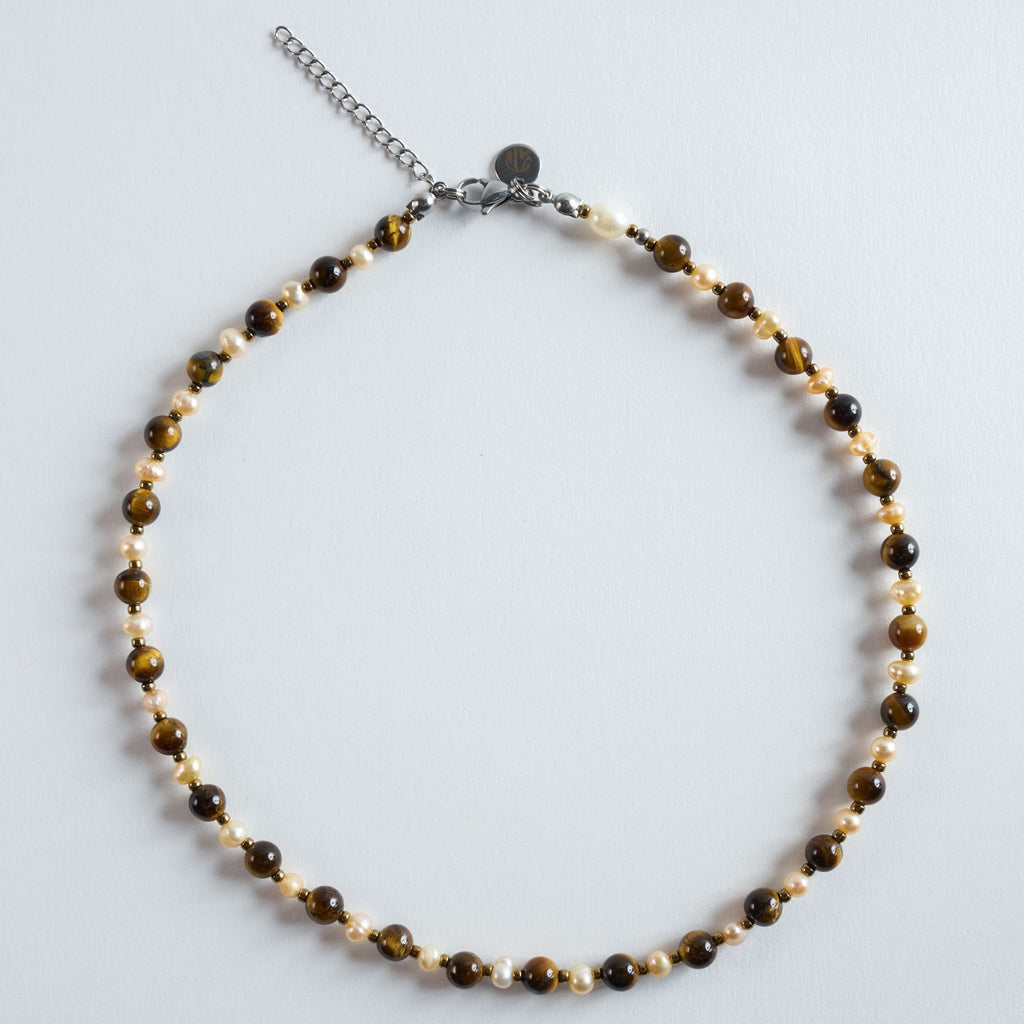 "Autumn Pearl" verbindet warm schimmerndes Tigerauge mit natürlichen Süßwasserperlen. Die goldbraunen Steine reflektieren das Licht besonders weich und erzeugen einen warmen, eleganten Gesamteindruck. In Kombination mit den Perlen entsteht ein harmonisches Spiel aus Glanz, Tiefe und natürlicher Struktur.