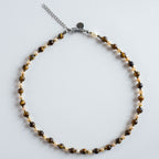 "Autumn Pearl" verbindet warm schimmerndes Tigerauge mit natürlichen Süßwasserperlen. Die goldbraunen Steine reflektieren das Licht besonders weich und erzeugen einen warmen, eleganten Gesamteindruck. In Kombination mit den Perlen entsteht ein harmonisches Spiel aus Glanz, Tiefe und natürlicher Struktur.