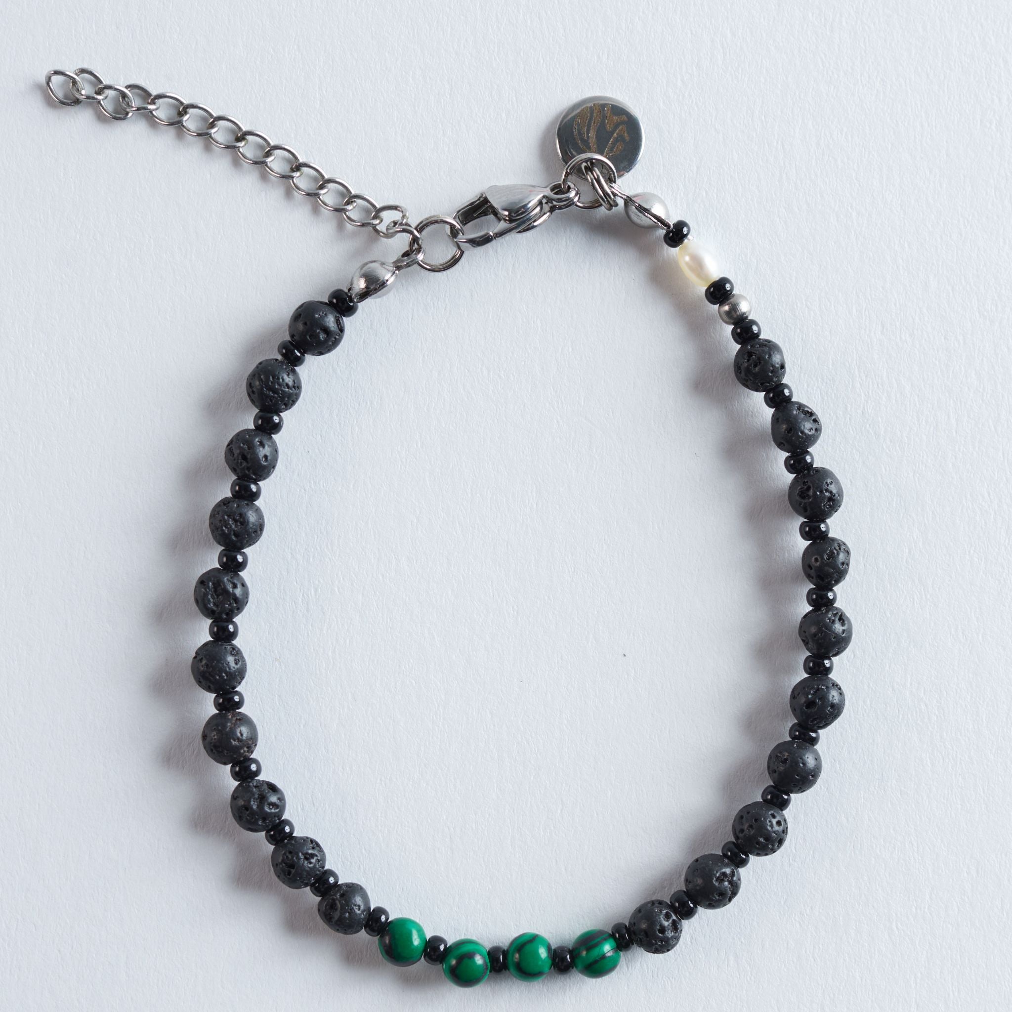 Das Armband Green Lava kombiniert tiefschwarzen Lavastein mit intensiv gemustertem Malachitperlen und feinen Glasperlen. Die markante, matte Struktur der Lava trifft auf ein lebendiges Grün, das dem Design einen modernen, frischen Charakter verleiht.