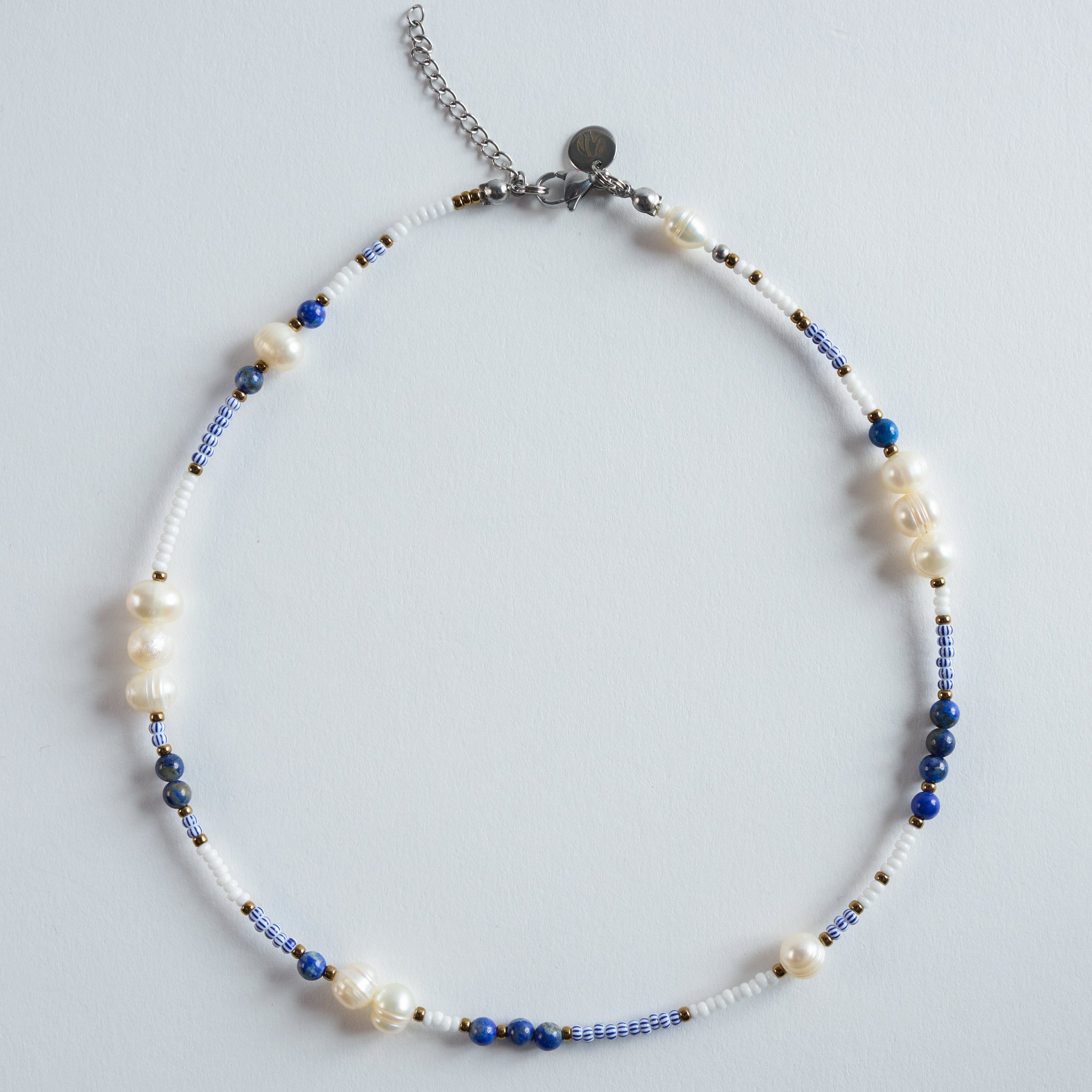 Die Perlenkette „Blue Chaos“ verbindet echte Süßwasserperlen mit tiefblauem Lapislazuli und klaren Glasperlen zu einem markanten, modernen Design.