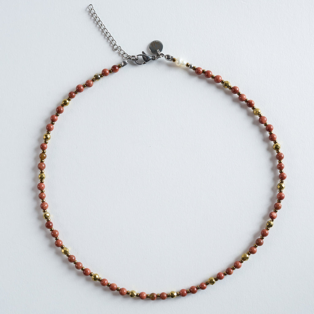 Die Halskette „Ember“ vereint warm schimmernden Goldfluss mit feinen, facettierten Hämatit-Details.