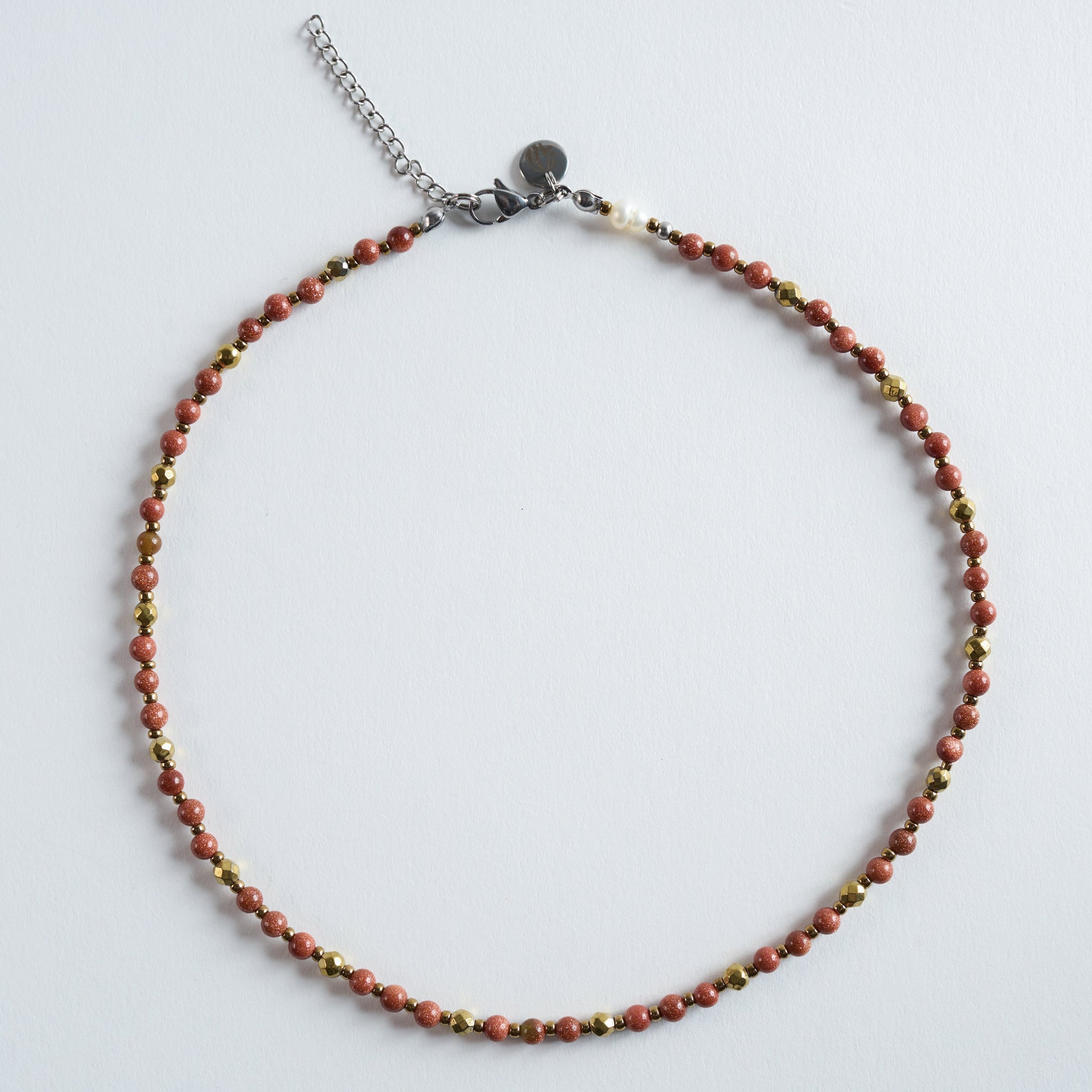 Die Halskette „Ember“ vereint warm schimmernden Goldfluss mit feinen, facettierten Hämatit-Details.