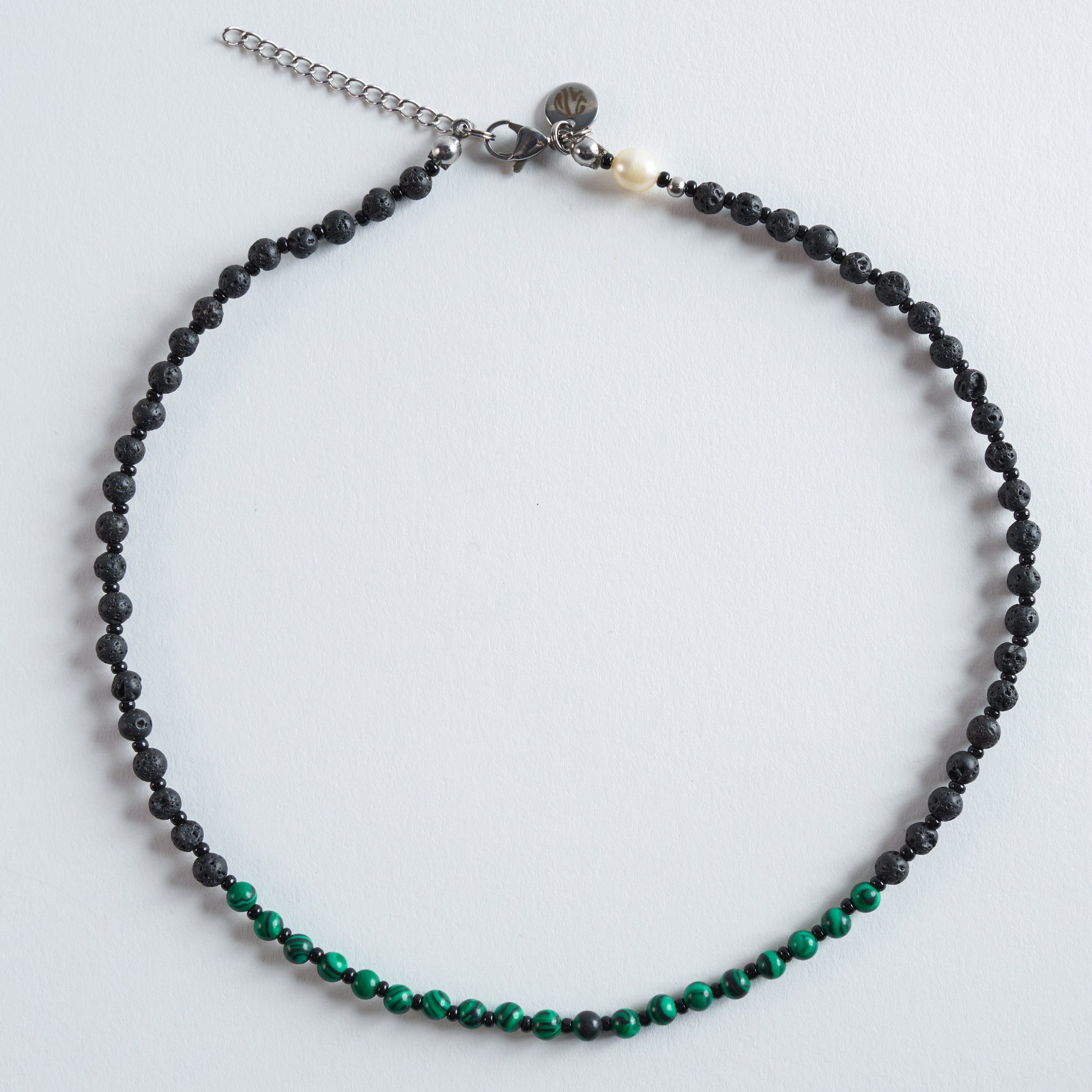 Diese Halskette vereint matten Lavastein mit hochwertigem Malachit-Imitat – modern, zeitlos und ideal für den Alltag. Jedes Schmuckstück wird einzeln gefertigt und erhält durch die grün marmorierte Musterung des Malachit-Imitats seinen ganz eigenen Charakter.

Farbe: Tiefes Schwarz trifft auf intensives, marmoriertes Grün. Die Kombination wirkt modern, natürlich und harmonisch. Ein eleganter Kontrast, der jedes Outfit abrundet.