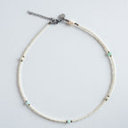 Die Halskette „Ice“ kombiniert zart schimmernde Süßwasserperlen mit einem klaren, mintgrünen Amazonit und feinen goldfarbenen Details. 