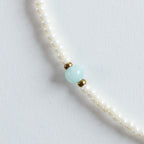 Ein Mix aus cremeweißen Süßwasserperlen, sanftem Mintgrün des Amazonits und goldenen Akzenten. Die Farbkombination wirkt klar, frisch und elegant.