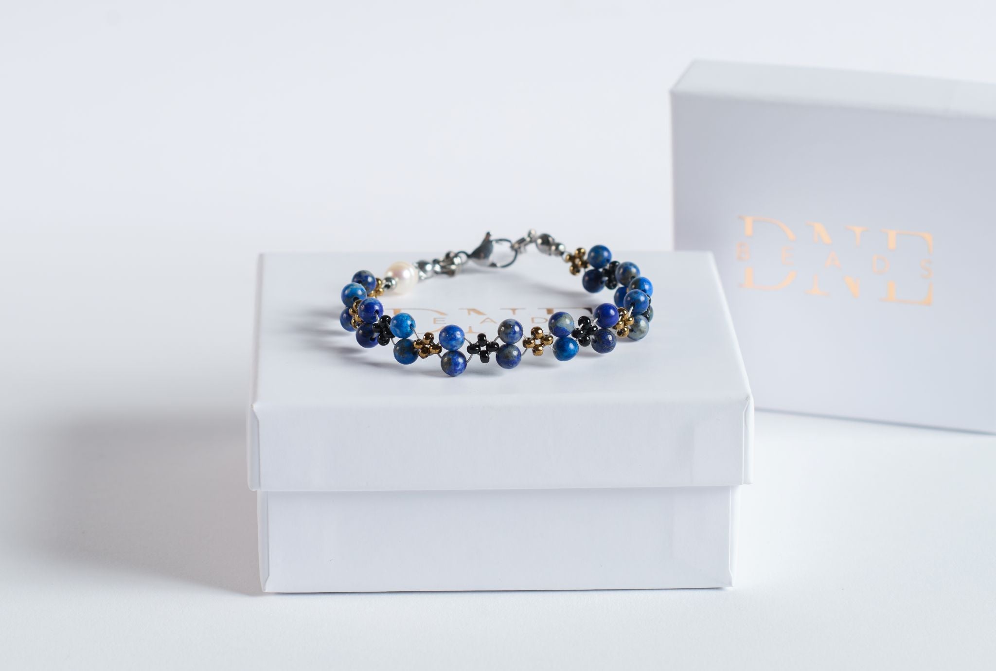 Das Twister-Armband Deep Sea verbindet die charakteristische Tiefe des Lapis Lazuli mit einer dynamischen Twister-Struktur, die an die Bewegung des Meeres erinnert.

Die intensiven Blautöne des Natursteins changieren je nach Lichteinfall zwischen Königsblau, Marine und kleinen goldenen Einschlüssen, die typisch für echten Lapis sind. Schwarze und goldfarbene Akzentperlen rahmen die Steine ein und verstärken die maritime Farbwelt.