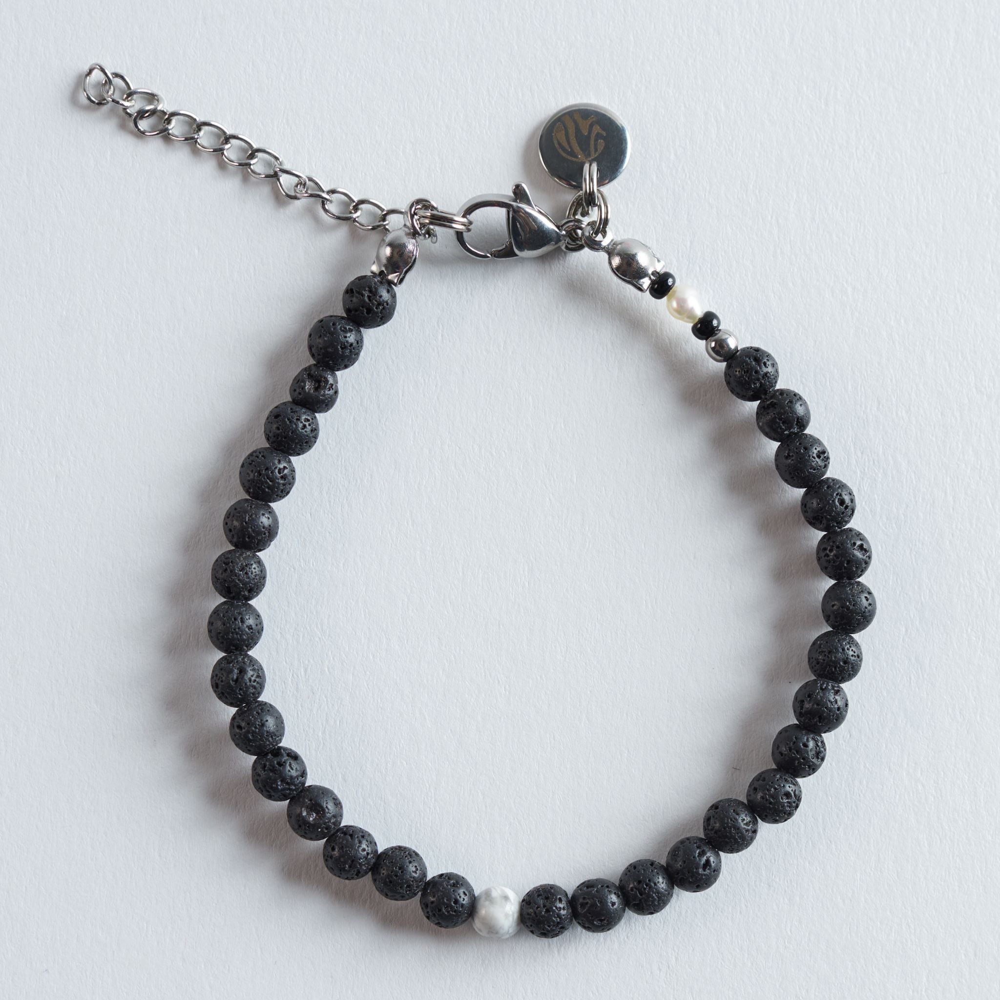 Das Armband Lava I White verbindet die dunkle, poröse Struktur des Lavasteins mit dem metallischen Glanz von Hämatit und der klaren, marmorierten Optik von Howlith. Schwarze und weiße Naturtöne treffen auf kühle Silberakzente und ergeben ein ruhiges, modernes Design.

Das Armband wirkt minimalistisch, ausgewogen und passt zu nahezu jedem Look.