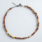 Die Halskette „Stone Flow“ kombiniert hochwertigen Mookait im natürlichen Rohschliff zu einem warmen, modernen Farbspiel. Die organischen Steinformen fließen harmonisch ineinander und erzeugen ein ruhiges, erdiges Gesamtbild.