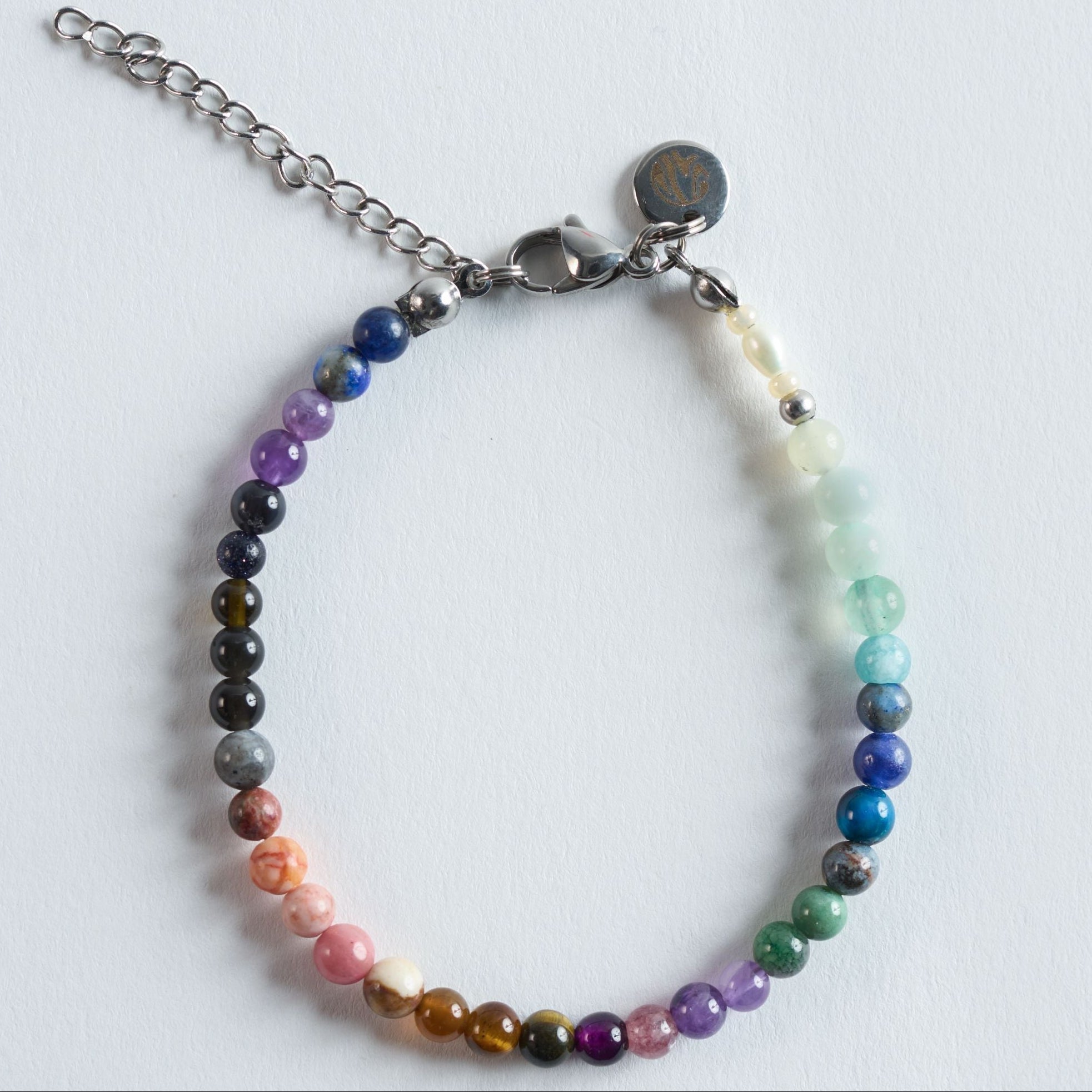 Das Armband Gentle Flow vereint ausgewählte Natursteine zu einem weichen, fließenden Farbverlauf, der von warmen Erdtönen über kräftige Blau- und Violettnuancen bis hin zu zarten Grün- und Minttönen reicht. Die sanften Übergänge lassen das Armband ruhig, harmonisch und ausgewogen wirken.