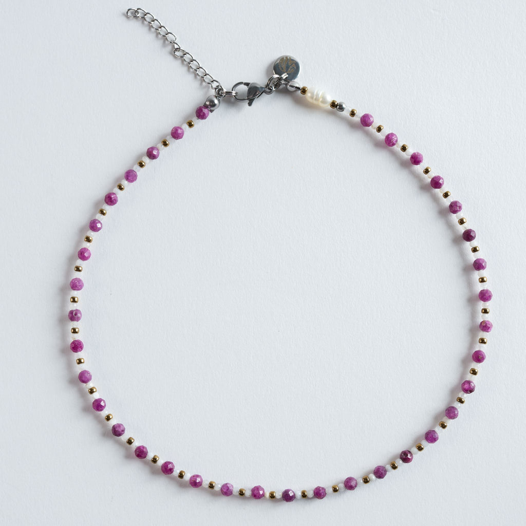 Die Halskette „Rubin – Essence“ kombiniert facettierte Rubinperlen mit hellen Zwischenperlen und goldfarbenem Hämatit. Die feinen Facetten erzeugen kleine Lichtreflexe, die den warmen Pinkton des Rubins elegant hervorheben. Ein modernes, hochwertiges Design mit klarer, femininer Ausstrahlung.