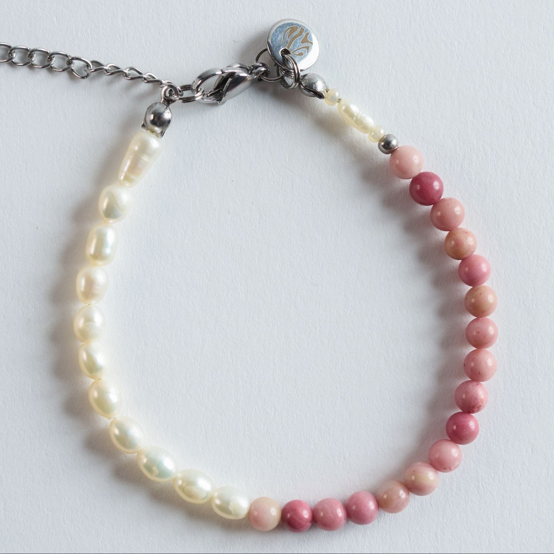 Das Armband Sweet Petal verbindet warmes Rosa mit dem sanften Schimmer echter Süßwasserperlen. Die runden Rhodonitsteine bringen eine zarte Farbintensität mit, die sich mühelos mit dem natürlichen Weiß der Perlen verbindet.