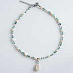 Die Halskette „Wave“ vereint feinen Aquamarin mit eleganten Süßwasserperlen und einem natürlichen Muschelanhänger.